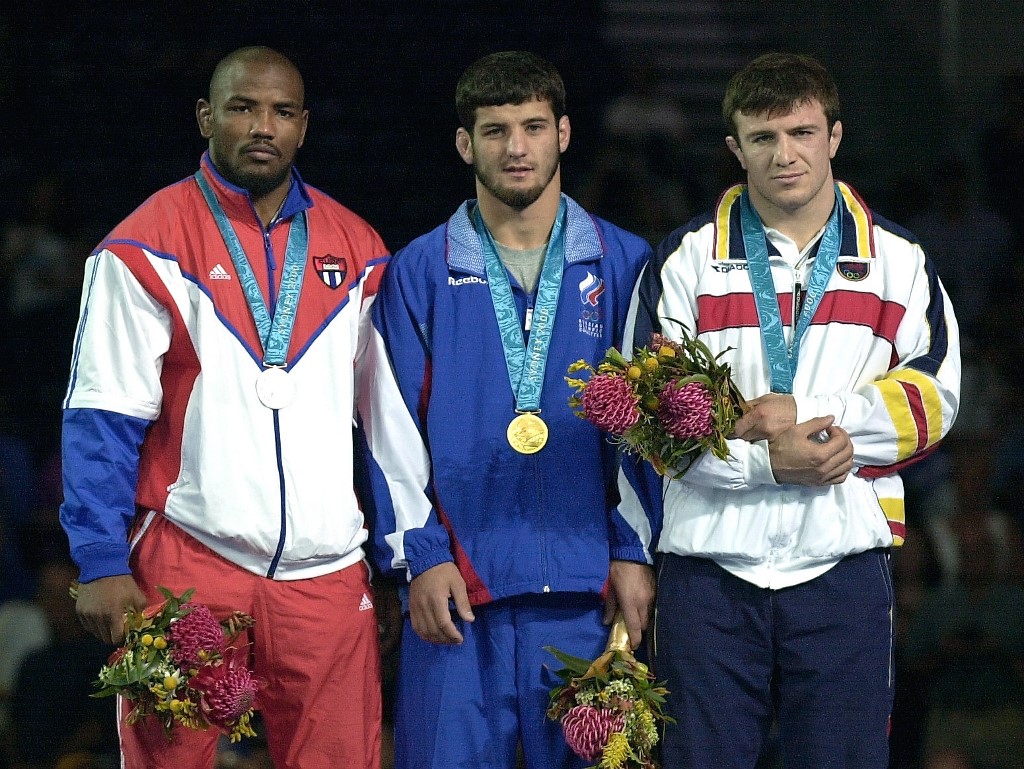 Gold medallist Adam Saitiev of Russia (C) stands with silver medallist Yoel Romero of Cuba (L) and bronze medallist Mogamed Ibragimov of Macedonia (R) during the awards ceremony for the 85kg freestyle wrestling competition at the XXVII Olympic Summer Games 01 October 2000 in Sydney.  AFP PHOTO/KIM Jae-Hwan (Photo by KIM JAE-HWAN / AFP)